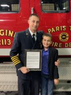 Chief Derek Reed poses with his son holding his Commendation Award