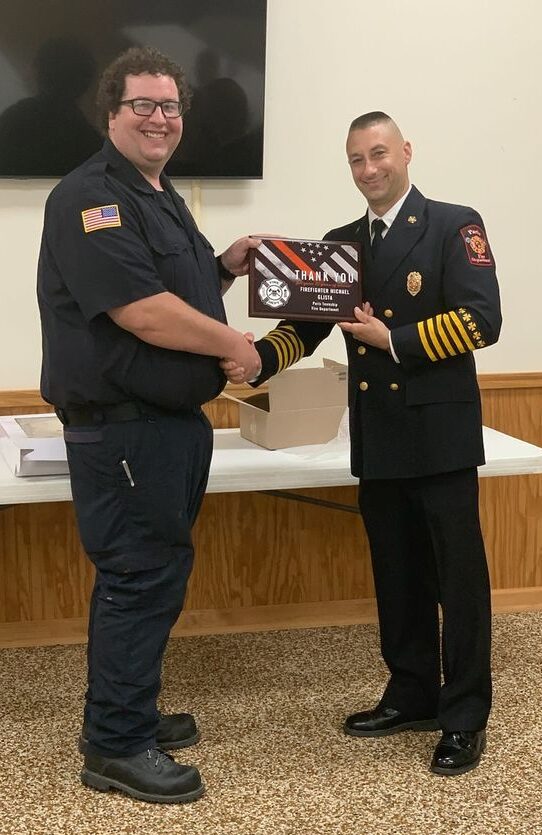 Michael Glista receives plaque and handshake from Paris Township Fire Chief